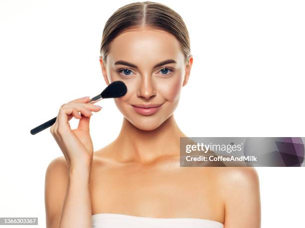 beautiful young woman applying foundation powder - blusher 個照片及圖片檔