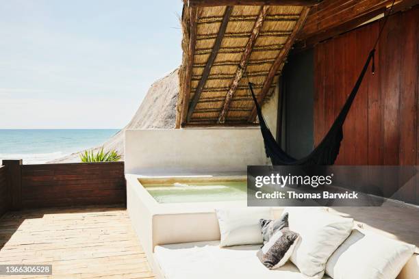 wide shot of plunge pool on deck of luxury tropical villa overlooking ocean - hotel grounds stock pictures, royalty-free photos & images