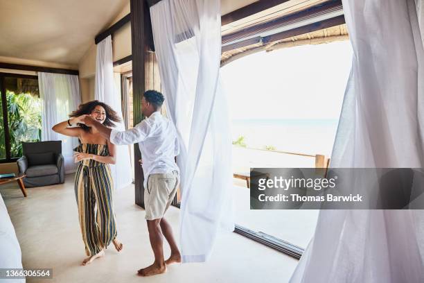 wide shot of couple dancing in luxury suite of tropical resort - hotel suite fotografías e imágenes de stock
