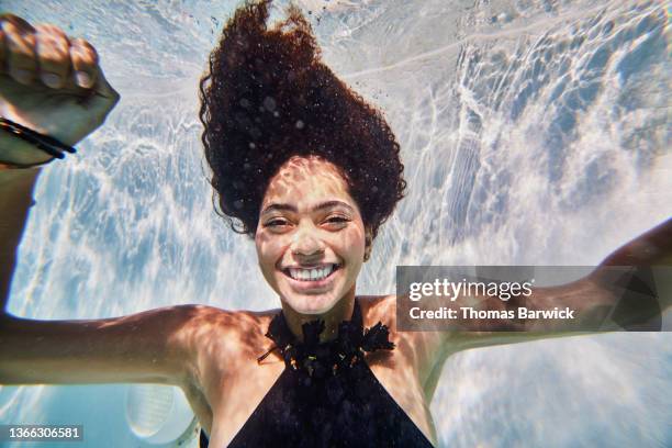 medium shot of smiling woman underwater in pool while on vacation - sous marin photos et images de collection