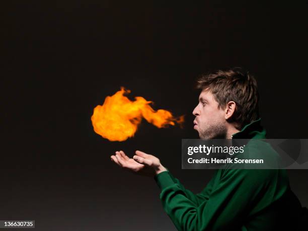 young man blowing fireball - bad breath stock pictures, royalty-free photos & images