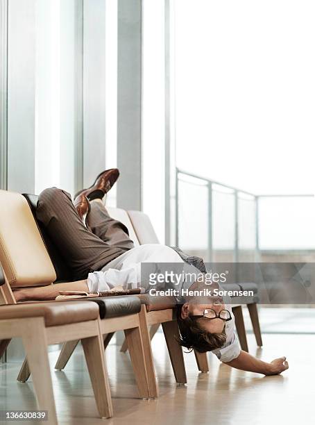 exhausted business man in waiting lounge - fatigue full body stock-fotos und bilder