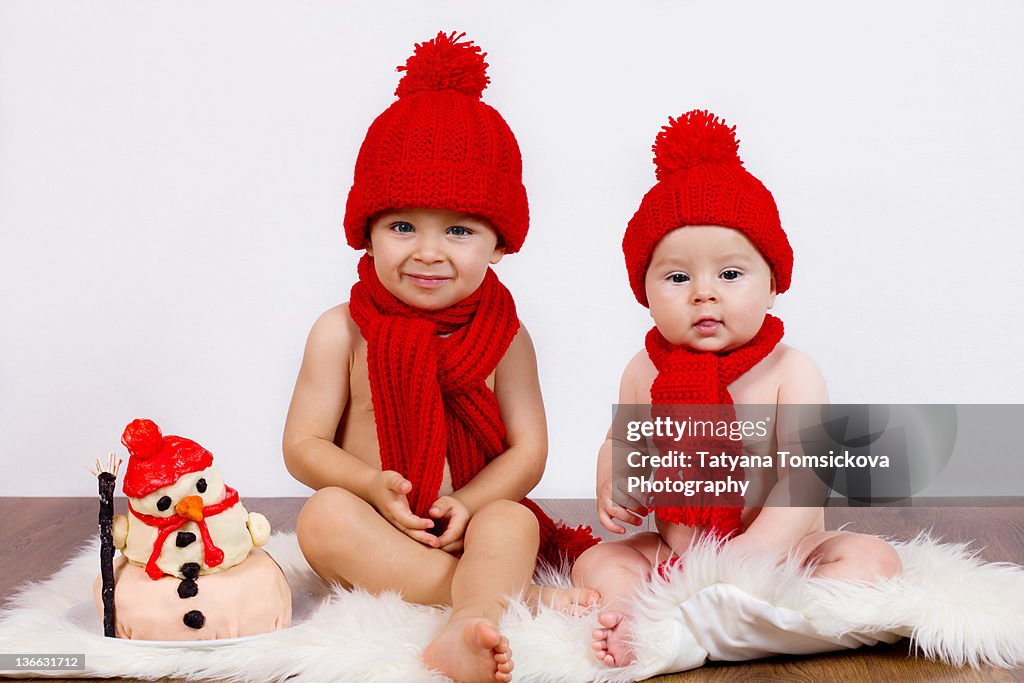 Two boys sitting on white rug