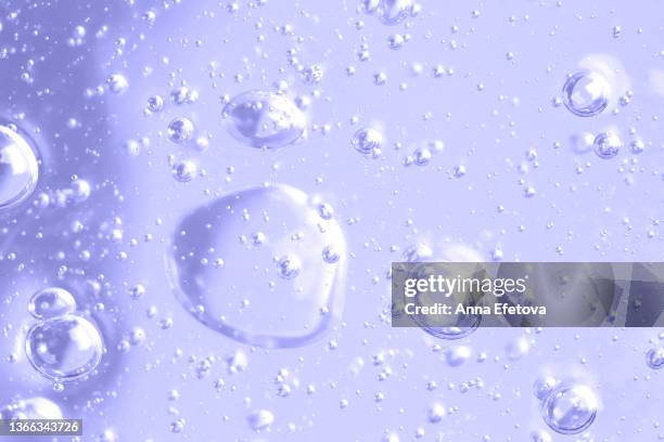 texture of organic transparent gel or lotion with many air bubbles on pastel violet background. macro photography in flat lay style with copy space. demonstrating very peri - color of 2022 year - chemical products stock-fotos und bilder