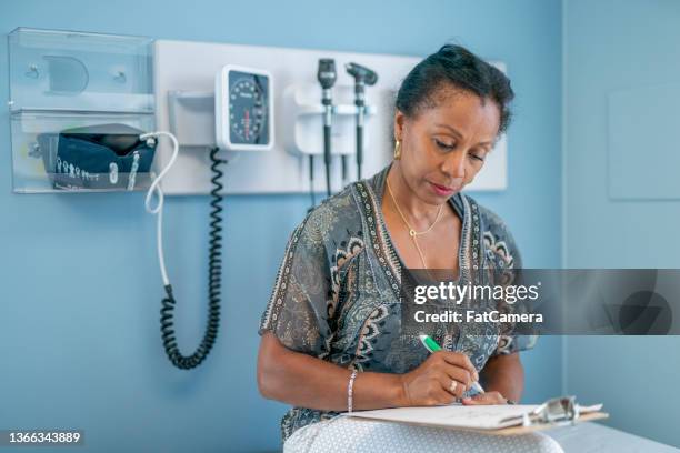 filling out forms in the doctor's office - examination table stock pictures, royalty-free photos & images