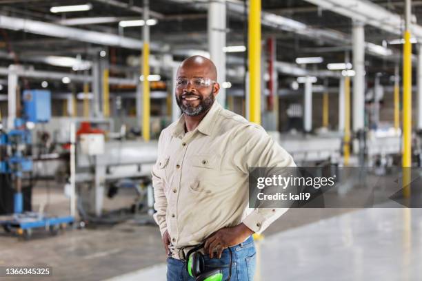 african-american man working in plastics factory - small business owner stockfoto's en -beelden