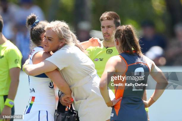 Danielle Laidley hugs Emma Kearney of the Kangaroos during the coin toss for the round three AFLW match between the North Melbourne Kangaroos and the...