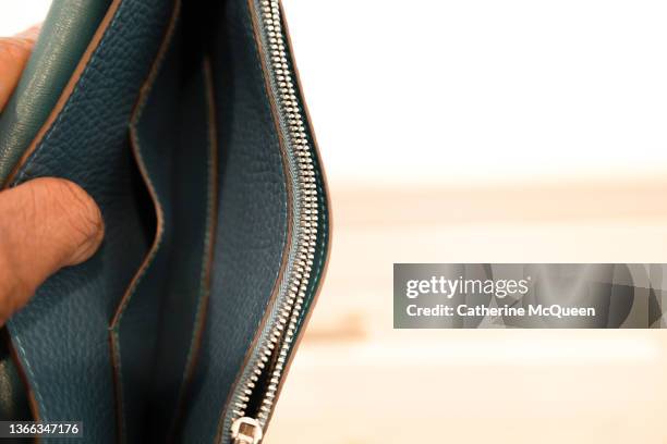 black woman checking her wallet finds she is out of cash - money borrow stockfoto's en -beelden