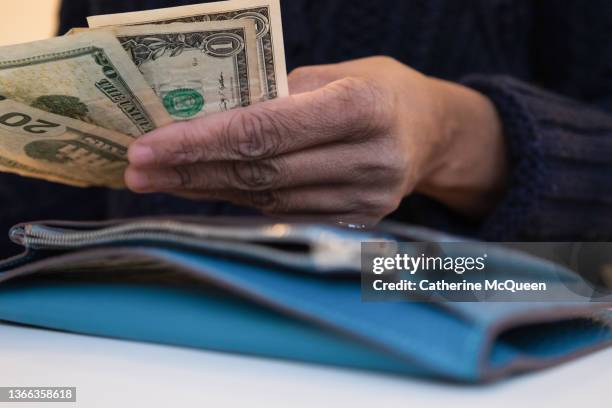 black woman counting money with wallet open on desk - us dollar note stockfoto's en -beelden