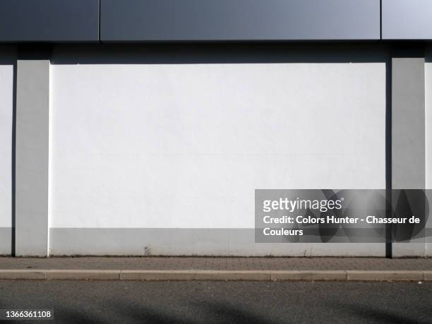 clean and empty facade of an industrial building with sidewalk and street in paris - le mur photos et images de collection
