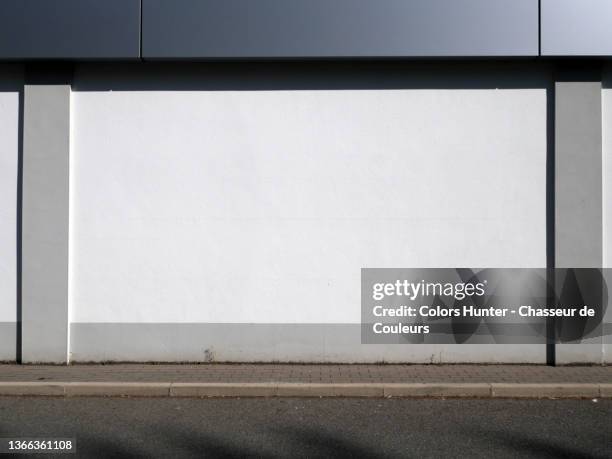 clean and empty facade of an industrial building with sidewalk and street in paris - painted walls stock pictures, royalty-free photos & images