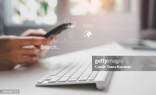job search hiring website, young business man searching for job online a hand holding to touch a phone. - looking for something stock-fotos und bilder