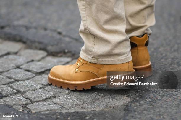 Hugo Compain wears beige denim jeans pants, brown suede laces ankle boots from Timberland, outside Loewe, during Paris Fashion Week - Menswear F/W...