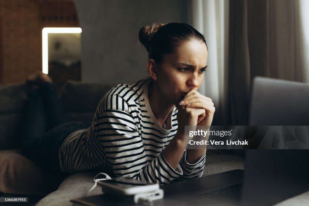 Stressed businesswoman working on laptop at home, tired freelancer