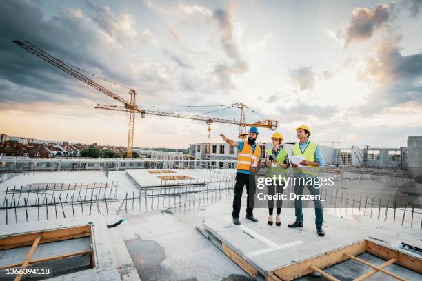 engenheiros bem sucedidos tendo reunião em canteiro de obras - obra - fotografias e filmes do acervo