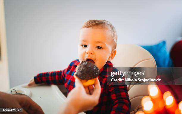 baby boy eats donuts - fat boys stockfoto's en -beelden