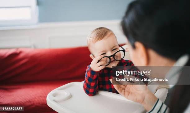 mom plays with glasses and with her baby - baby eye doctor stock pictures, royalty-free photos & images