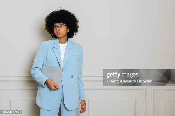 business lady african american woman standing with laptop on white wall background in office business portrait .business and finance concept - simplification at work stock-fotos und bilder
