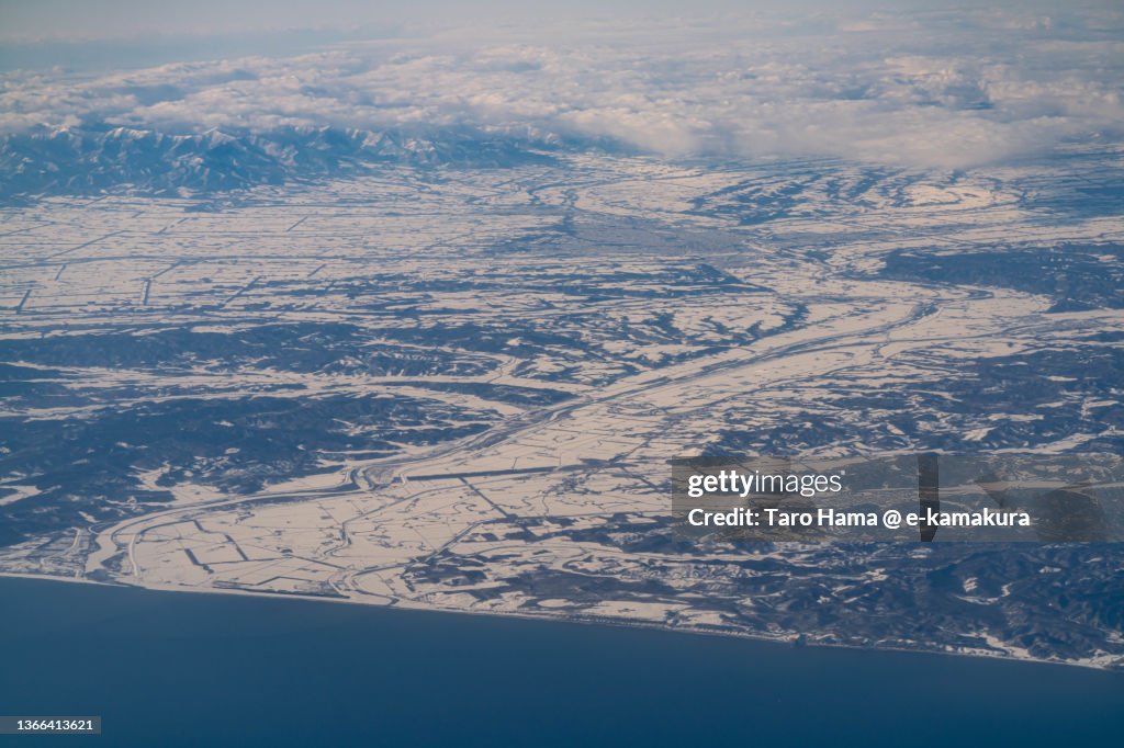 Snowcapped Hidaka Mountains and Obihiro city in Hokkaido of Japan aerial view from airplane