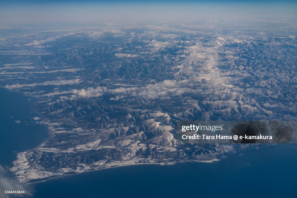 Snowcapped Hidaka Mountains and Cape Erimo in Hokkaido of Japan aerial view from airplane
