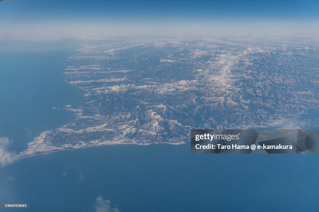 Snowcapped Hidaka Mountains and Cape Erimo in Hokkaido of Japan aerial view from airplane