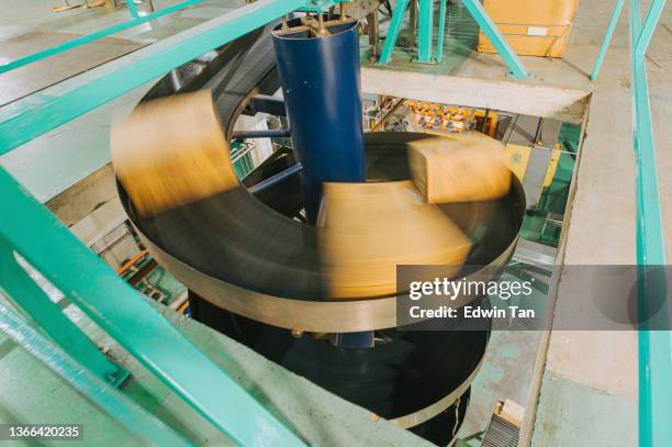 motion blurred mineral water factory production line spiral conveyor belt moving carton to warehouse packing area - boxes conveyor belt stock pictures, royalty-free photos & images