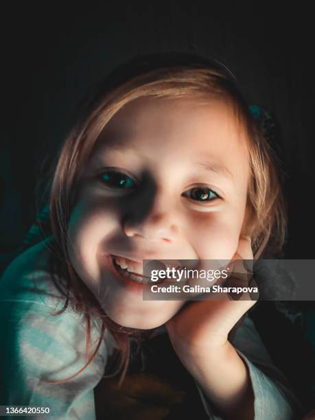 Little Caucasian girl smiling and looking at camera, lifestyle photography at home