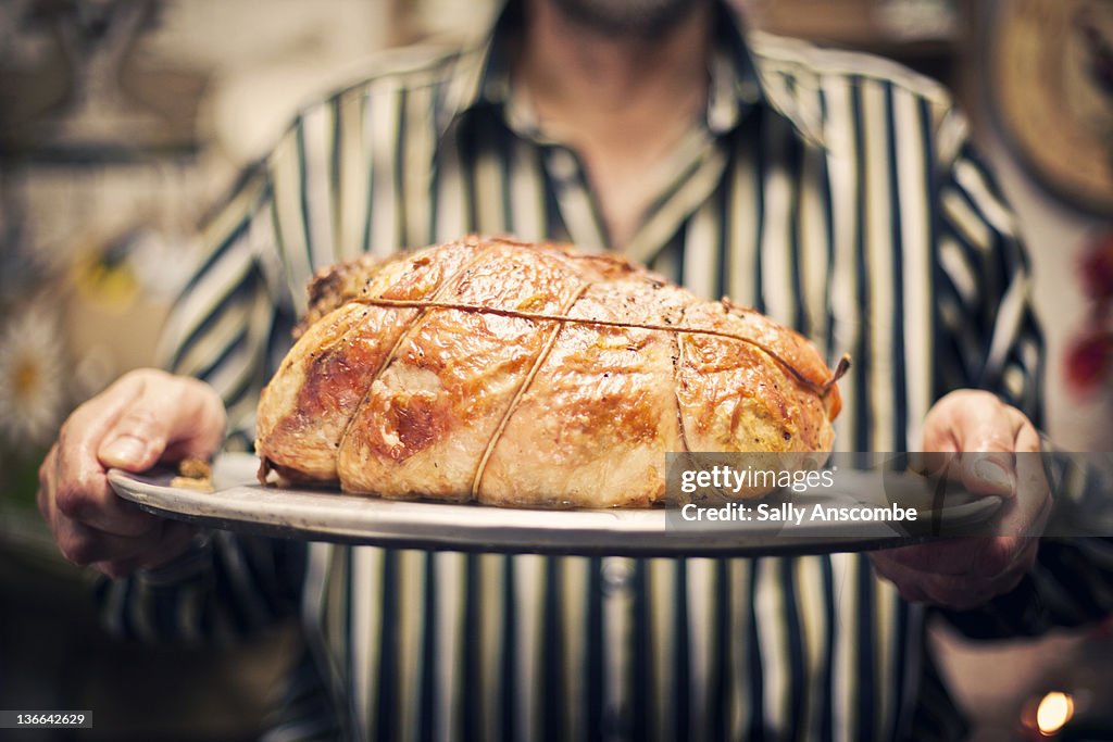 Man holding roast turkey