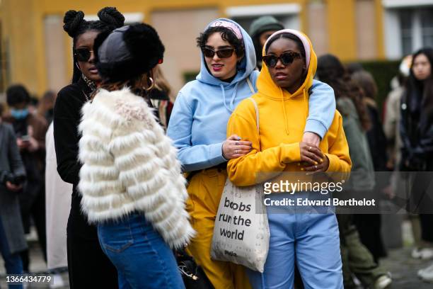 Guest wears a black fur hat, red sunglasses, gold earrings, a white fur / fluffy coat, ,blue denim large jeans pants, a guest wears a pale pink and...