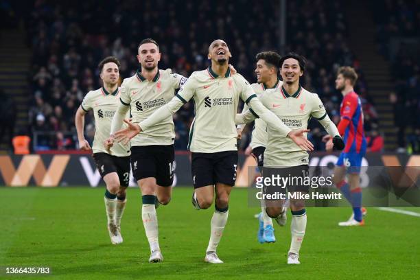 Fabinho of Liverpool celebrates with teammates Jordan Henderson and Takumi Minamino after scoring their side's third goal from the penalty spot...