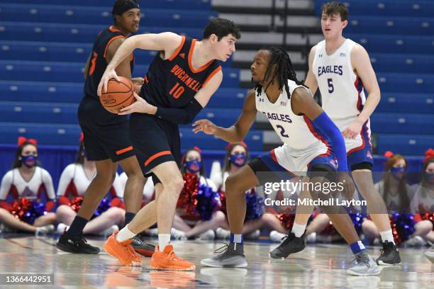 Andrew Funk of the Bucknell Bison tries to get around Stacy Beckton Jr. #2 of the American University Eagles during a college basketball game at...