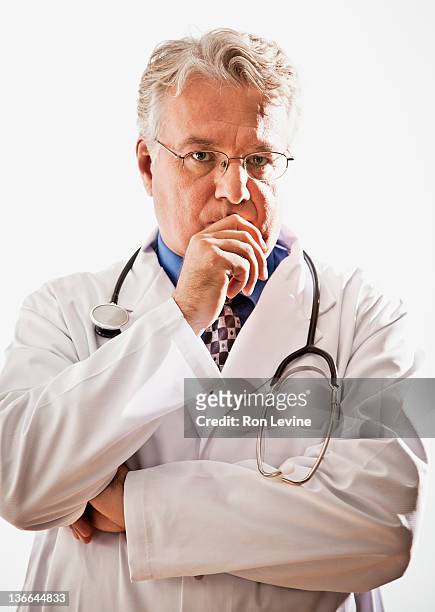 mature doctor looking worried, portrait - kin in de hand stockfoto's en -beelden