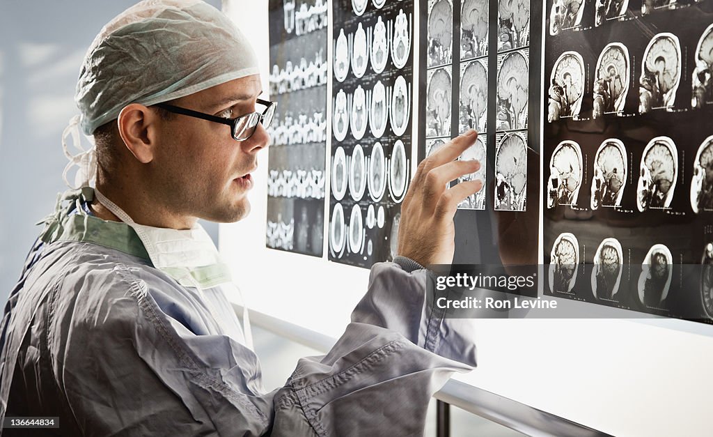 Doctor in surgical wear examines mri scan