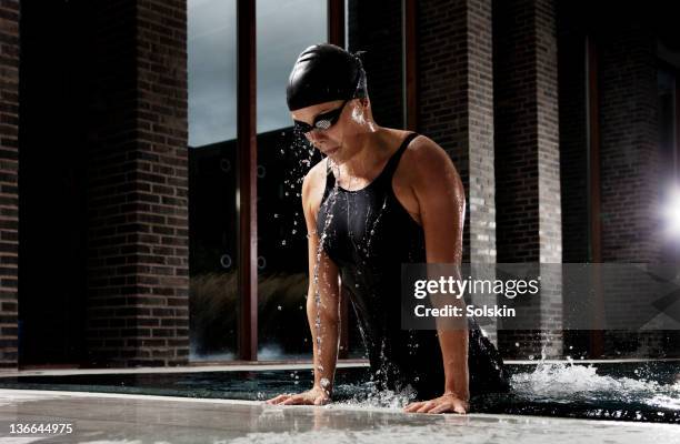 female swimmer getting out of pool - emerge stock pictures, royalty-free photos & images