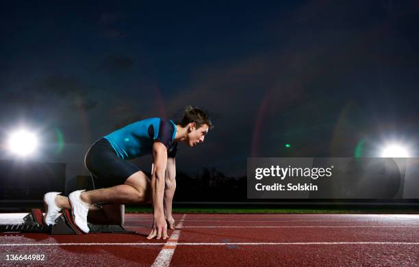 track and field sprinter getting ready in blocks - 起跑架 個照片及圖片檔