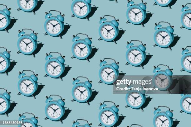 pattern of alarm clocks on a blue background - clock photos et images de collection