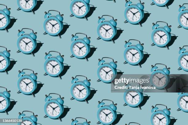 pattern of alarm clocks on a blue background - tempo concetto foto e immagini stock