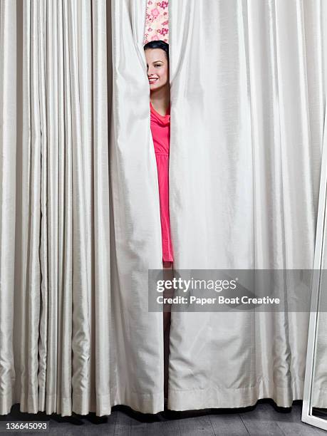 young lady peeking out of the dressing room - fitting room stock pictures, royalty-free photos & images