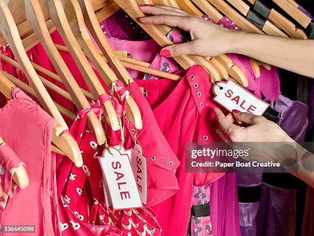 lady picking out dresses with a sale tag on it - tag 1 ストックフォトと画像