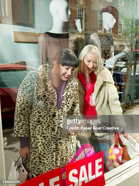 friends looking at a shop window with sale sign - boxing day stock pictures, royalty-free photos & images