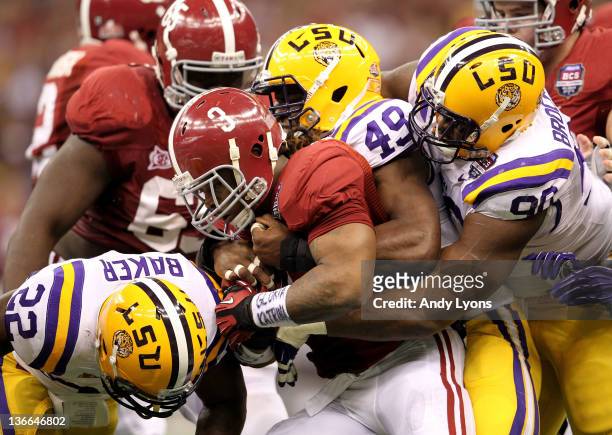 Trent Richardson of the Alabama Crimson Tide gets tackled by Ryan Baker, Barkevious Mingo and Michael Brockers of the Louisiana State University...