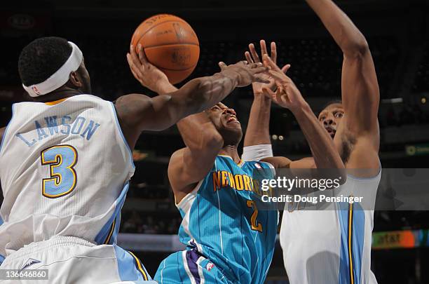 Jarrett Jack of the New Orleans Hornets tries to get off a shot against Ty Lawson of the Denver Nuggets and has it blocked by Nene Hilario of the...