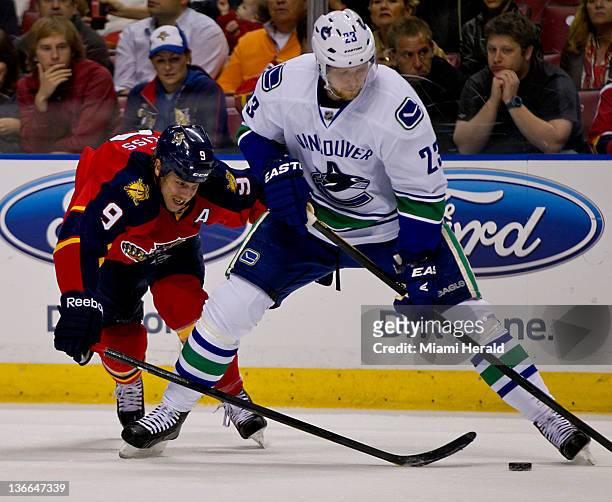 Stephen Weiss of the Florida Panthers reaches in on Vancouver Canucks defenseman Alexander Edler in the first period at Bank Atlantic Center in...