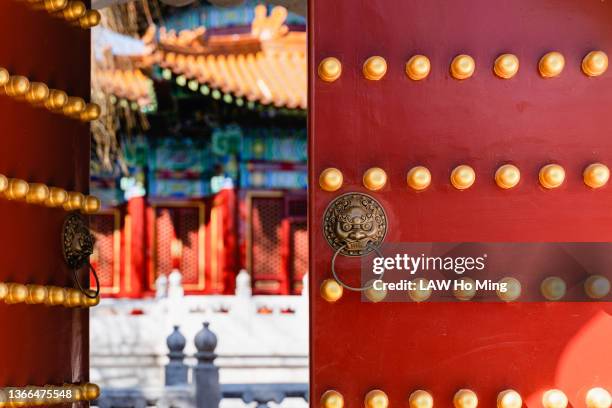 golden lion head door knocker on red door in china. - knocker_(folklore) stock pictures, royalty-free photos & images
