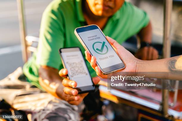 customer paying tuk-tuk taxi fare by contactless payment with qr code on a smartphone - digital wallet stock pictures, royalty-free photos & images