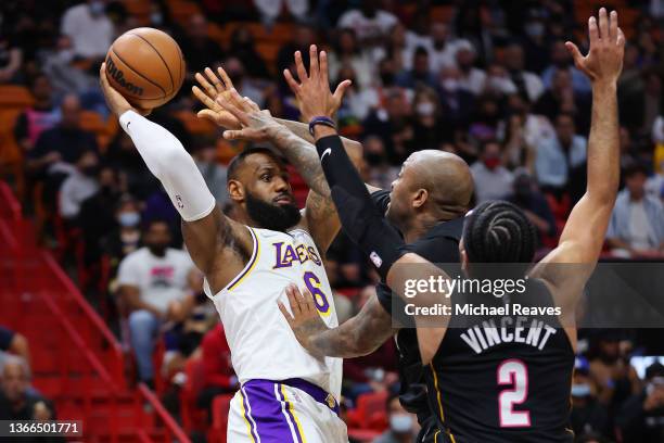 LeBron James of the Los Angeles Lakers passes around P.J. Tucker and Gabe Vincent of the Miami Heat during the first half at FTX Arena on January 23,...