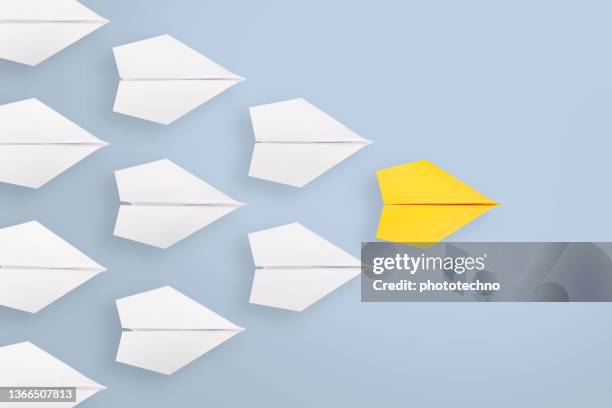 leadership concepts with yellow paper airplane leading among white - follow stockfoto's en -beelden