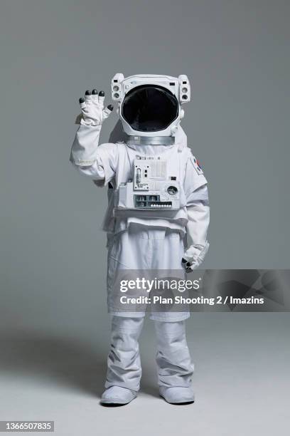 an astronaut waving hands - astronaut hand stock pictures, royalty-free photos & images