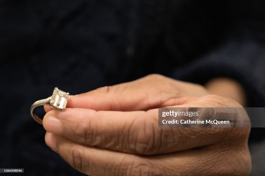 Black woman holds diamond engagement ring
