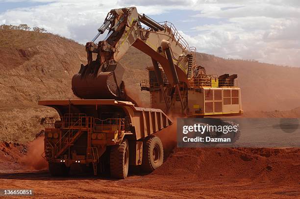 dell'escavatore caricamento del minerale in un camion trasportare. - mining equipment foto e immagini stock